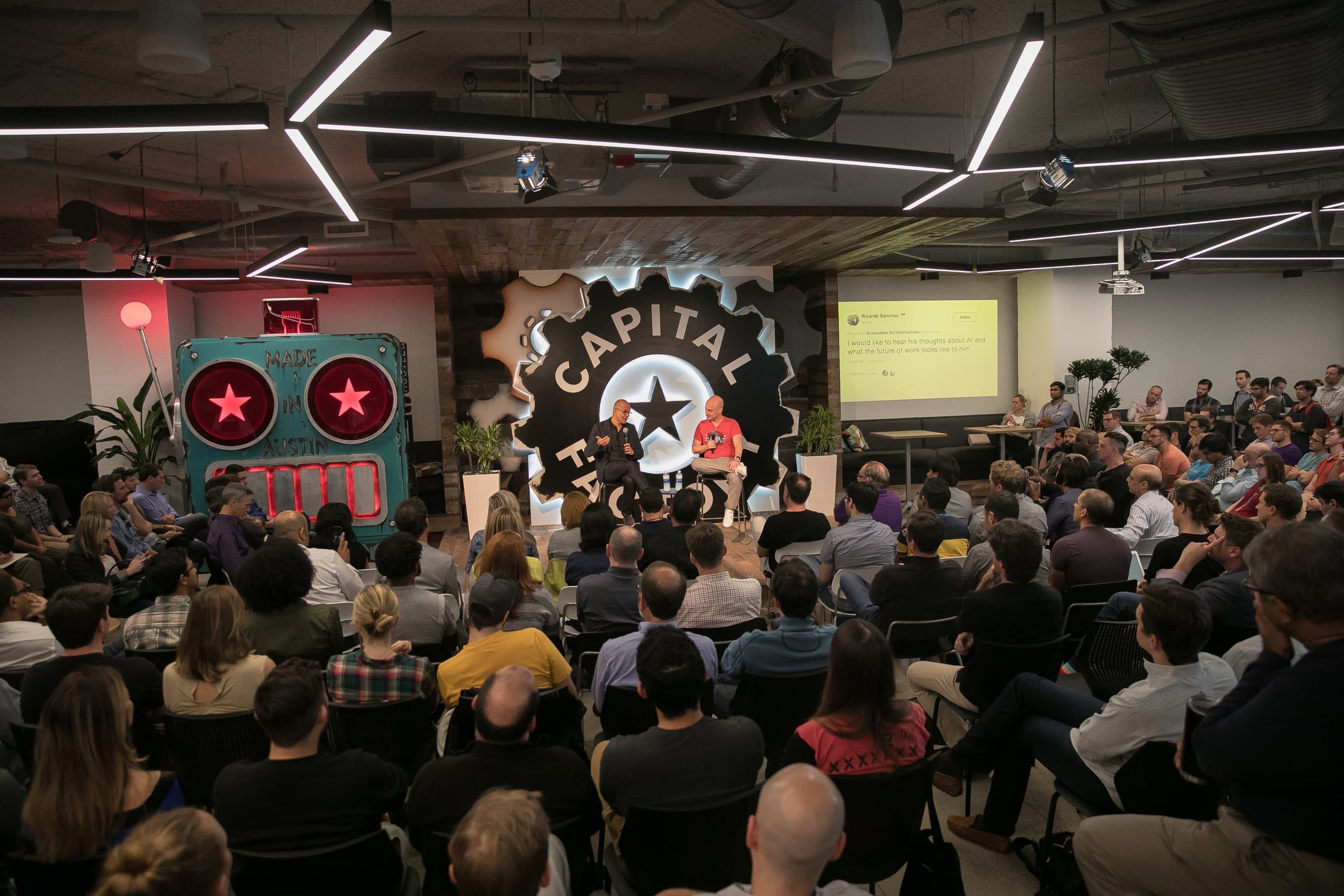 A demo-day fireside chat under the Capital Factory gear logo